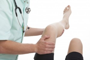 Doctor treating arthritis patient's sore knee joint