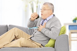 Man with COPD coughing on his couch