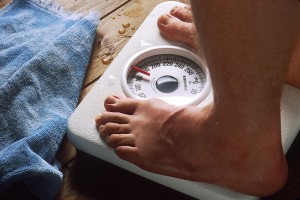 Overweight person standing on weight scale