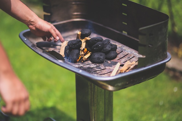 Man prepares the grill for a heart healthy cookout this June