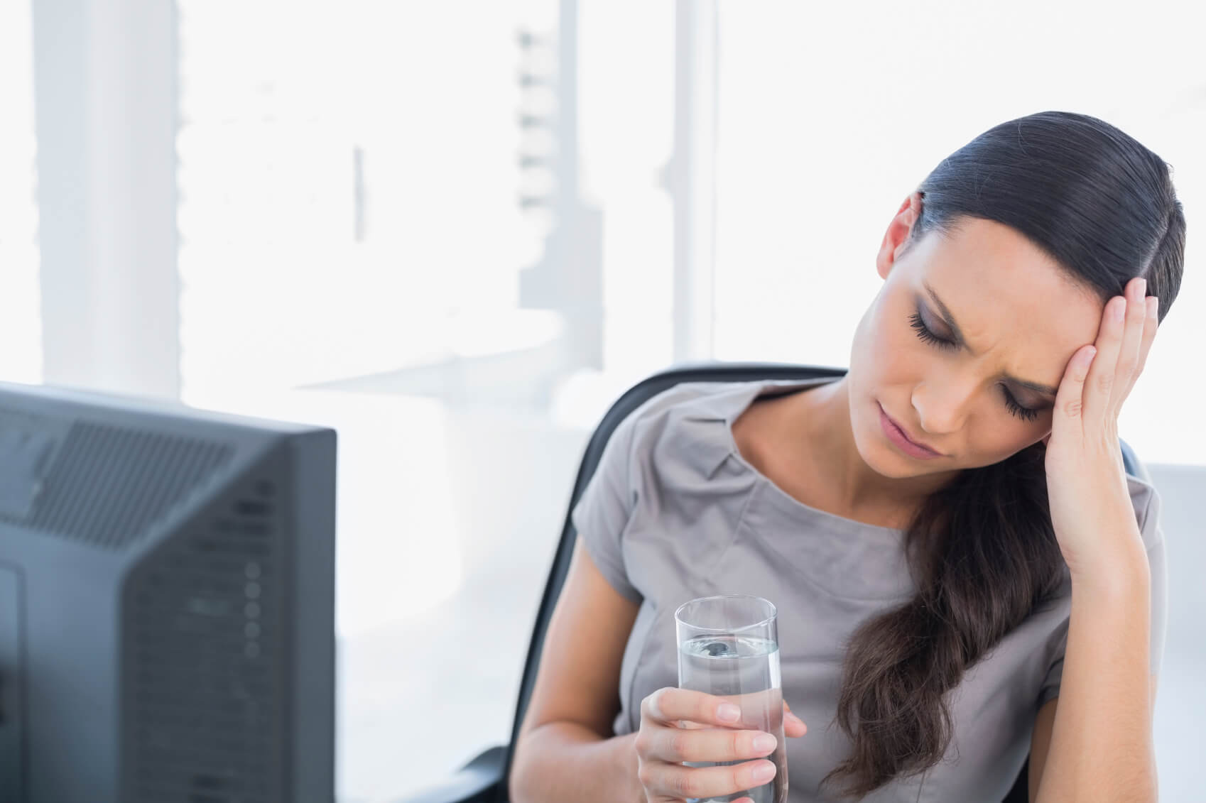 Woman suffering from a migraine at work